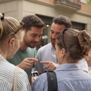 A group of young friends gather around a smartphone while playing a city game in Funchal.