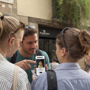 A group of young friends gather around a smartphone to play a city game on a street in Bern.