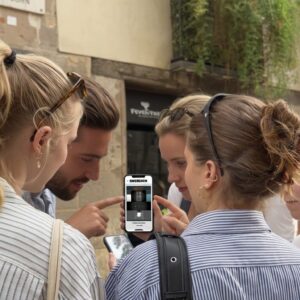 A group of friends stands together on a street in Shibuya, looking at a smartphone to solve a puzzle.