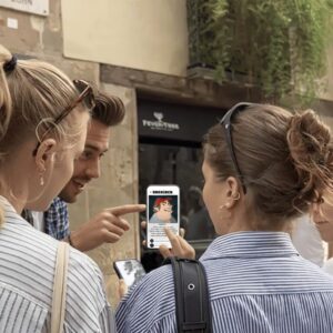 A group of young friends gather around a smartphone playing an interactive Sherlock city game in Uppsala.